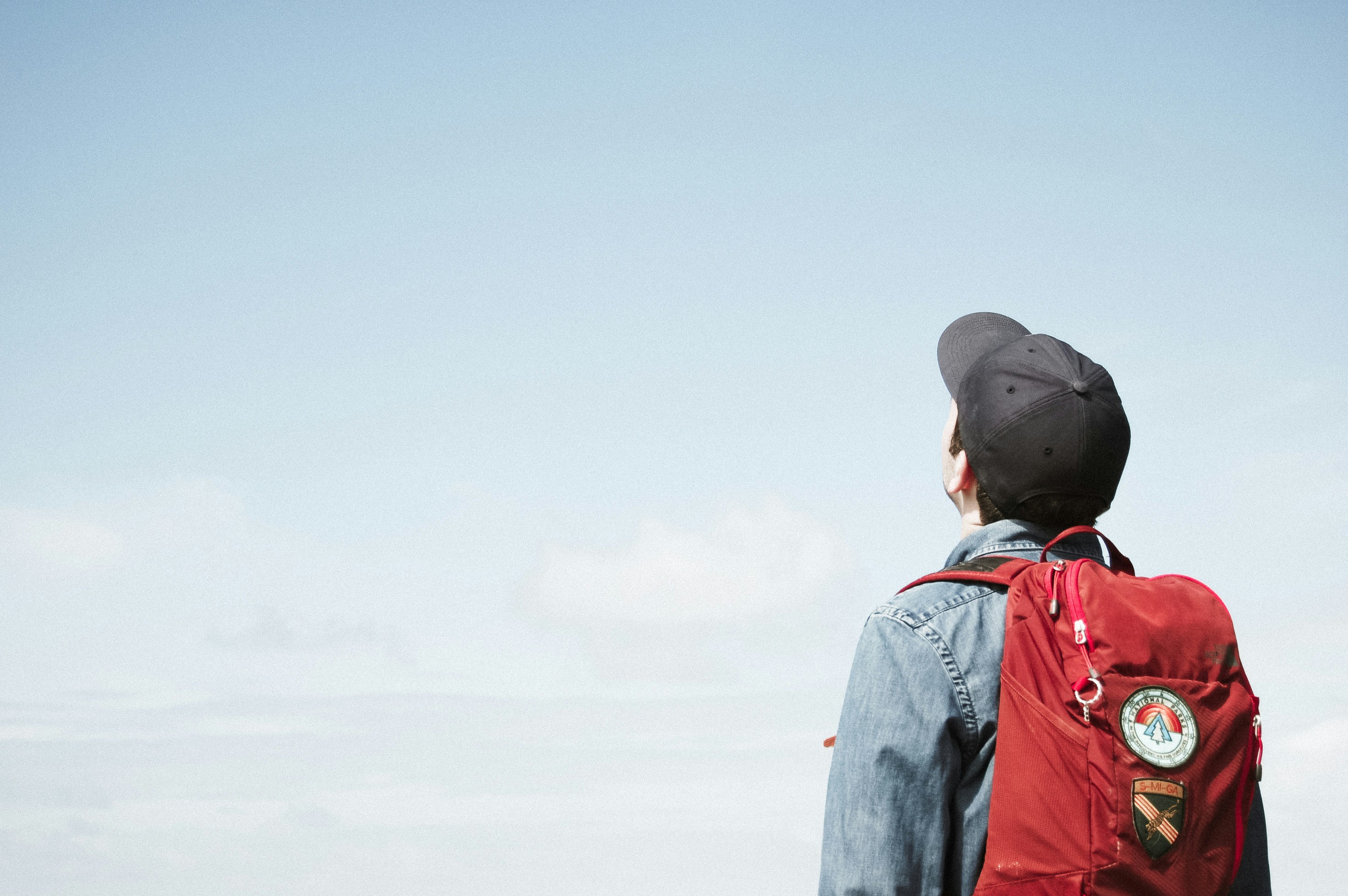 A student with a backpack looking out at an open sky