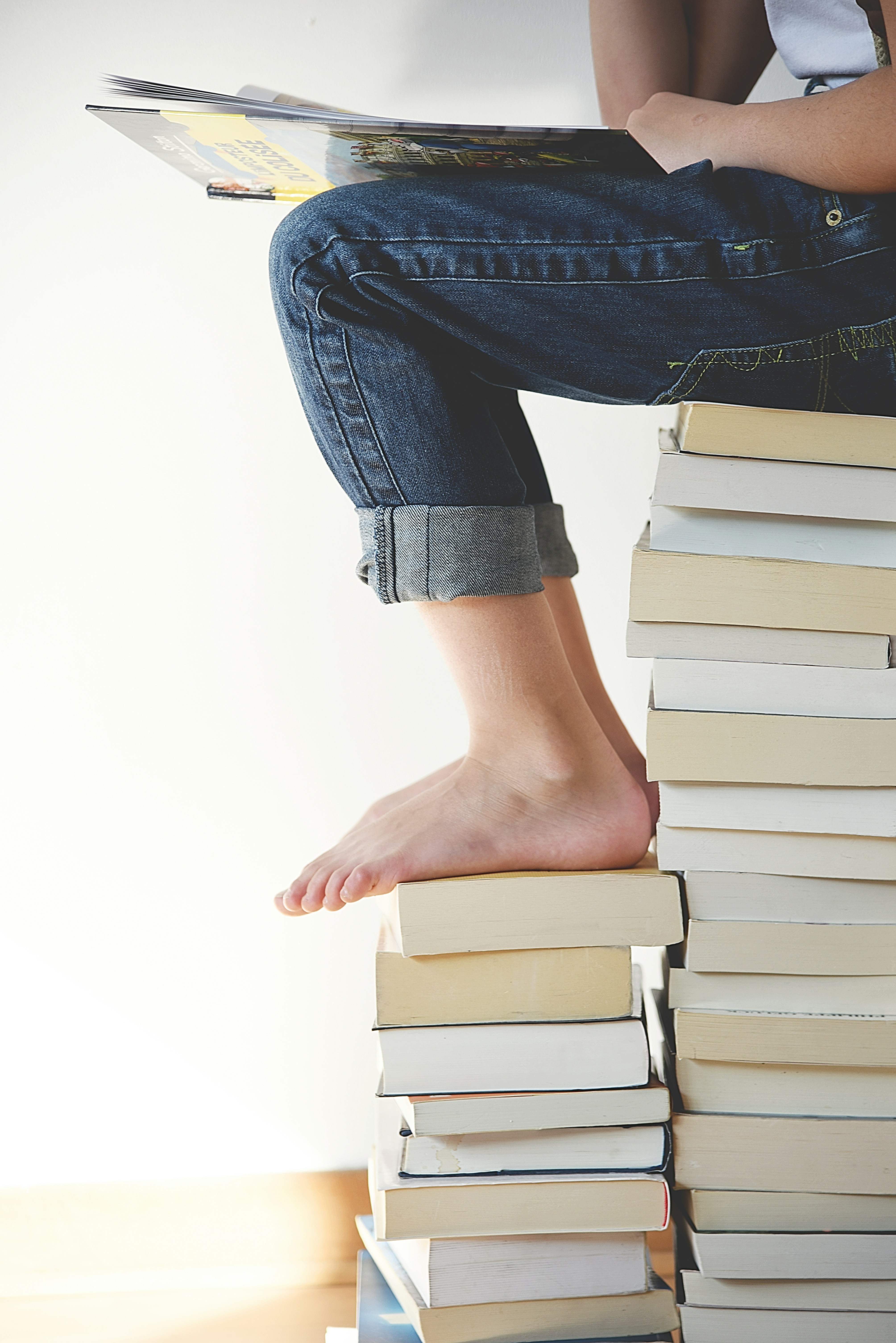 Person reading on a stack of books