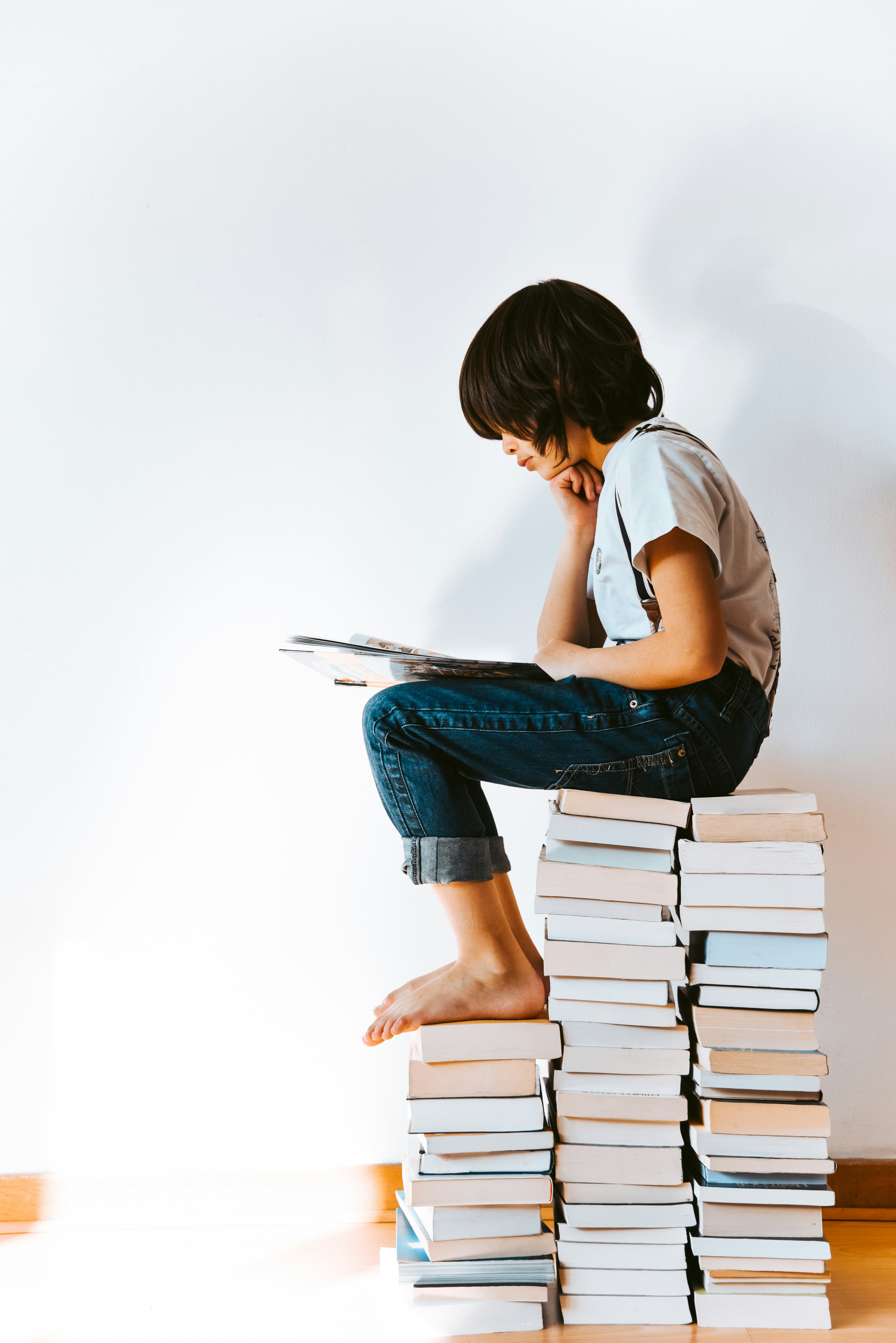 Student reading on a stack of books