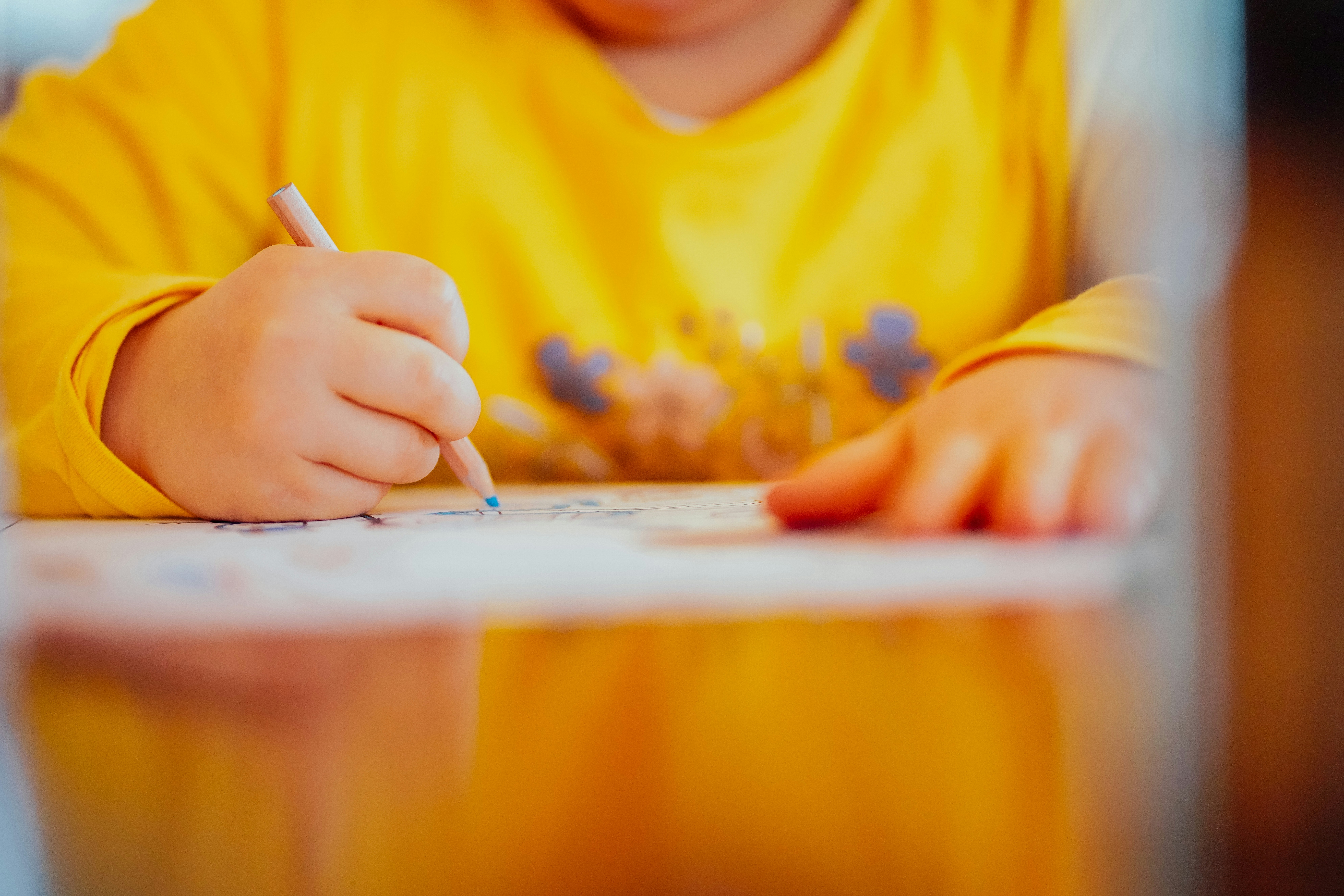 A young student working on a writing task at a desk